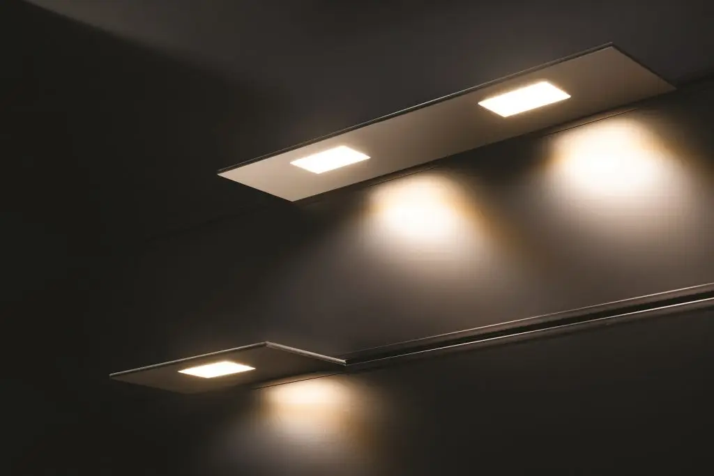 Bespoke minimalist linear architectural light profiles from System 77 by OZ Lighting, casting warm ambient illumination against a modern textured concrete wall.